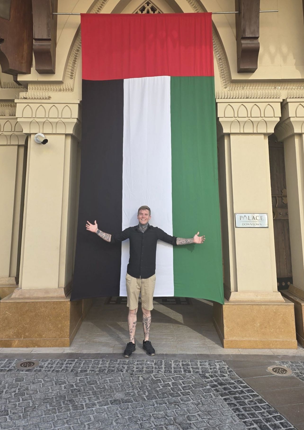 Ty-Shane Howell standing in front of the United Arab Emirates flag